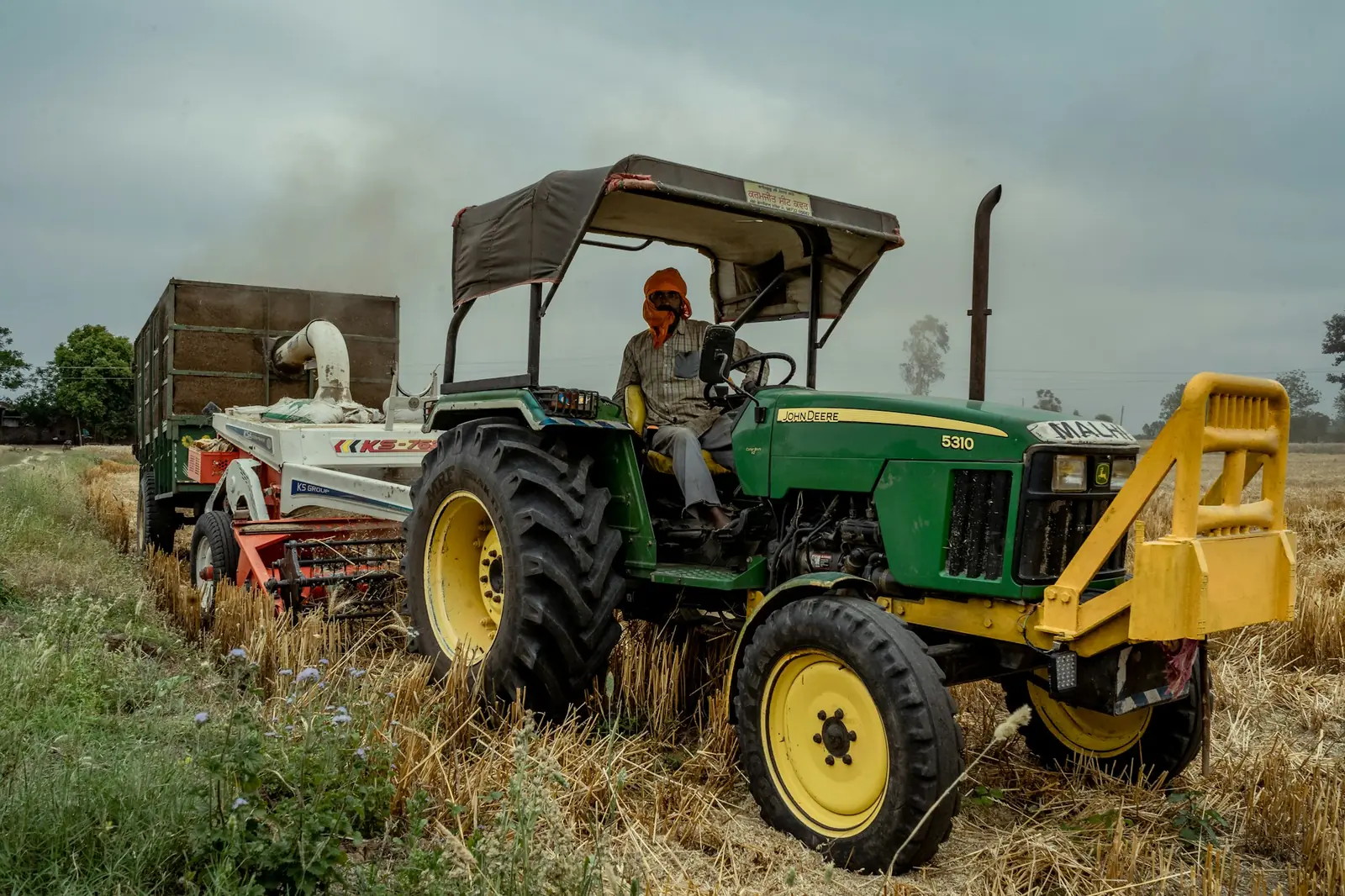 Tractor operator working a field with a trailer attached